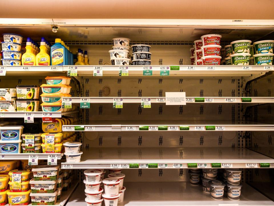 Butter and cheese shelves are seen empty at a supermarket in Miami Beach, Florida on January 13, 2022