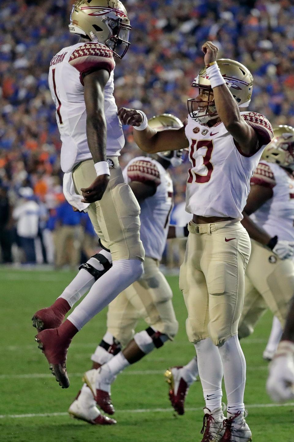 Florida State quarterback Jordan Travis, right, celebrates with quarterback James Blackman after Travis scored on a 1-yard run against Florida during the first half of an NCAA college football game Saturday, Nov. 30, 2019, in Gainesville, Fla. (AP Photo/John Raoux)