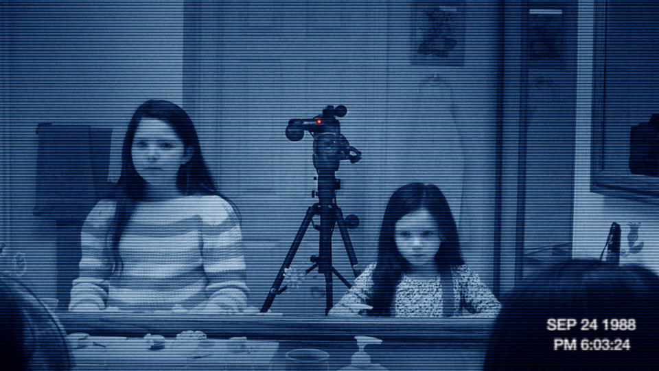 Two little girls stare in a mirror