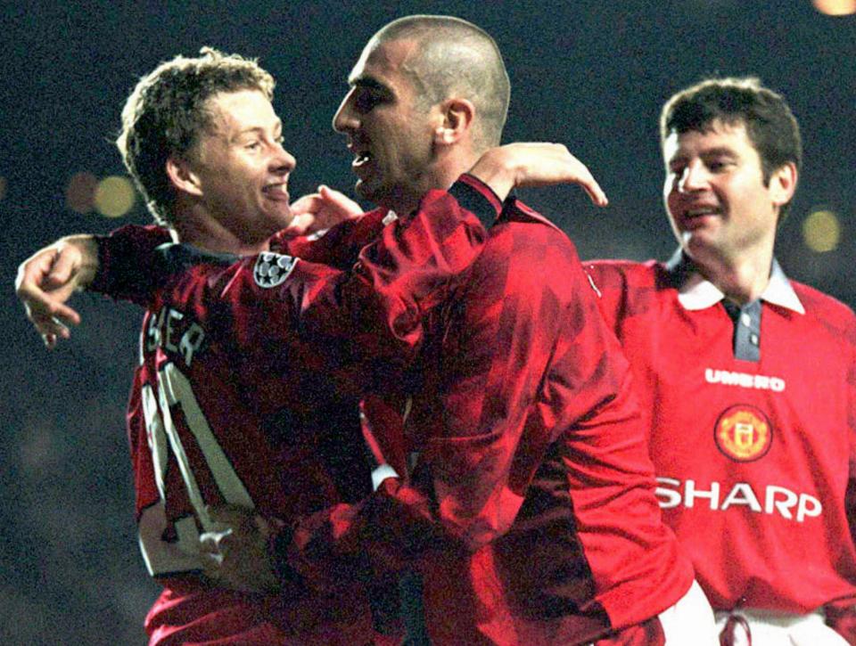 Manchester United captain Eric Cantona, center, congratulates Ole Solskjaer, left, as team mate Dennis Irwin, at right looks on after Solskjaer opened the scoring for Manchester United against Rapid Vienna in their UEFA Champions league soccer match at Old Trafford, Manchester Wednesday, September 25, 1996. (AP Photo/Dave Kendall)  --UNITED KINGDOM OUT--