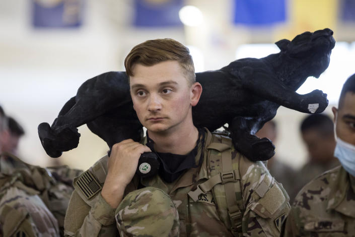 A soldier with the U.S. Army 3rd Infantry Division, 1st Armored Brigade Combat Team holds the brigade mascot while being deployed to Germany from Hunter Army Airfield, Wednesday March 2, 2022 in Savannah, Ga. The division is sending 3,800 troops as reinforcements for various NATO allies in Eastern Europe. (Stephen B. Morton /Atlanta Journal-Constitution via AP)
