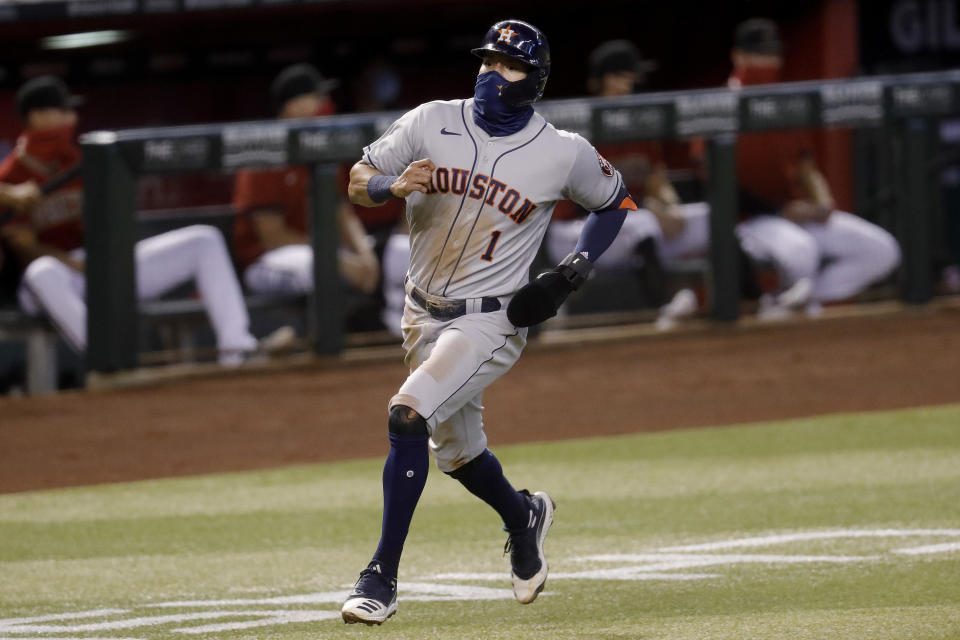 Houston Astros' Carlos Correa (1) scores on a base hit by teammate Abraham Toro during the second inning of a baseball game against the Arizona Diamondbacks Wednesday, Aug. 5, 2020, in Phoenix. (AP Photo/Matt York)