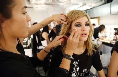 A model has her makeup redone before the presentation of the Tom Ford Spring/Summer 2015 collection during London Fashion Week September 15, 2014. REUTERS/Suzanne Plunkett