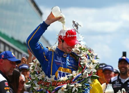 May 29, 2016; Indianapolis, IN, USA; IndyCar Series driver Alexander Rossi dunks himself with milk as he celebrates after winning the 100th running of the Indianapolis 500 at Indianapolis Motor Speedway. Mandatory Credit: Mark J. Rebilas-USA TODAY Sports