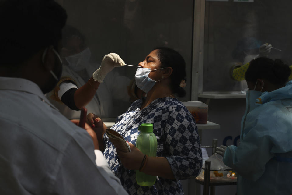 A health worker takes a nasal swab sample of a woman to test for COVID-19 in Hyderabad, India, Monday, May 3, 2021. COVID-19 infections and deaths are mounting with alarming speed in India with no end in sight to the crisis. People are dying because of shortages of bottled oxygen and hospital beds or because they couldn’t get a COVID-19 test. (AP Photo/Mahesh Kumar A.)