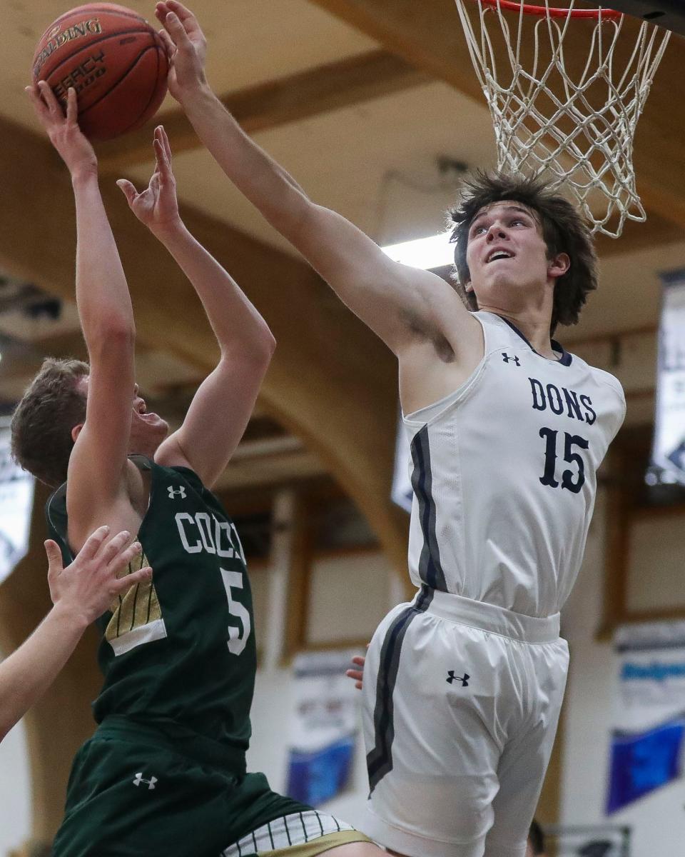 Columbus Catholic's Grant Olson (15) blocks a shot by Colby's Richard Streveler during a game Tuesday at Columbus Catholic High School in Marshfield.