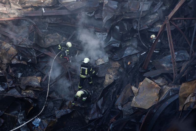 Firefighters work at the site of a House of Culture hit by a Russian missile strike in Kharkiv