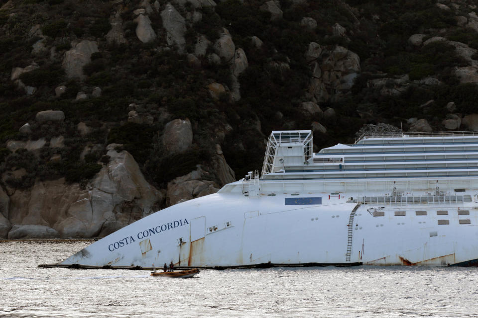 A view of the partially sunk Costa Concordia wreckage next to the Giglio Island, Italy, Sunday, Oct. 14, 2012. The first hearing of the trial for the Jan. 13, 2012 tragedy, where 32 people died after the luxury cruise Costa Concordia was forced to evacuate some 4,200 passengers after it hit a rock while passing too close to the Giglio Island, is taking place in Grosseto Monday Oct. 15, 2012. Captain Schettino, who was blamed for both the accident and for leaving the ship before the passengers, is scheduled to attend the hearing. (AP Photo/Gregorio Borgia)