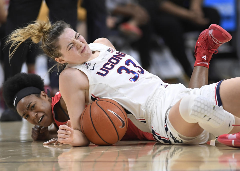 Connecticut's Katie Lou Samuelson, top and Houston's Julia Blackshell-Fair fall to the court chasing a loose ball during the first half of an NCAA college basketball game, Saturday, March 2, 2019, in Storrs, Conn. Samuelson left the game injured after the play. (AP Photo/Jessica Hill)