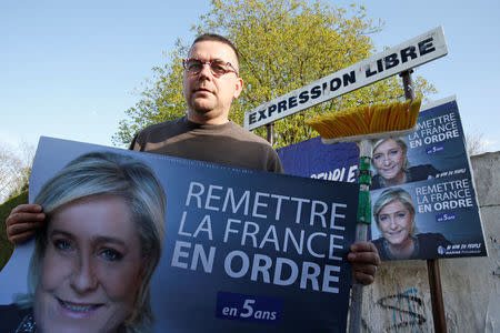 Emmanuel Rignaux, a member of the National Front party, poses as he pastes posters for French far right National Front political party leader Marine Le Pen as part of the 2017 French presidential election campaign, in Henin-Beaumont, France, April 6, 2017. REUTERS/Pascal Rossignol