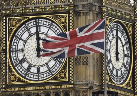 A British Union Jack flag is seen flying near a face of the clocktower at the Houses of Parliament in London, Britain, February 1, 2016. REUTERS/Toby Melville