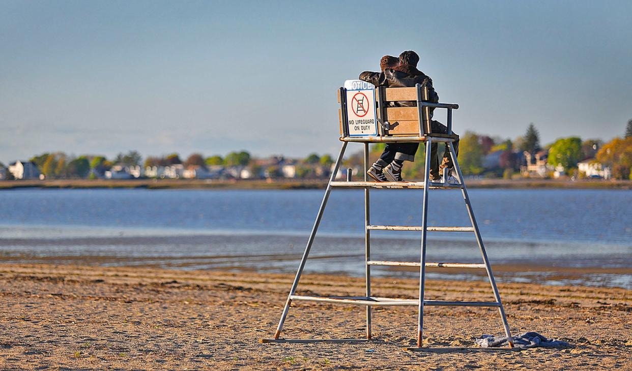 A couple enjoy the late-afternoon sun at Wollaston Beach in Quincy.