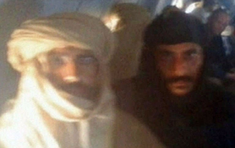 An image grab taken from the Libya Al-Ahrar TV station shows Seif al-Islam (L), the fugitive son of ousted and killed Libyan leader Moamer Kadhafi, guarded by a Libyan fighter as they sit on an aircraft at an air strip in the town of Zintan, after he was captured in southern Libya