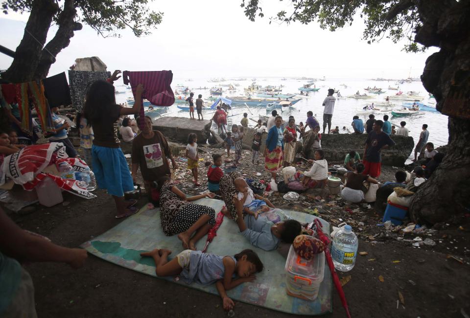 Villagers rest at Zamboanga port after fleeing their homes due to fighting between Moro National Liberation Front (MNLF) rebels and government soldiers in Zamboanga city September 11, 2013. (REUTERS/Erik De Castro)