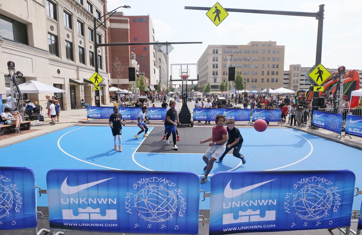 Players take part in the 3v3 Courtyard Classic basketball tournament on a pop-up court.