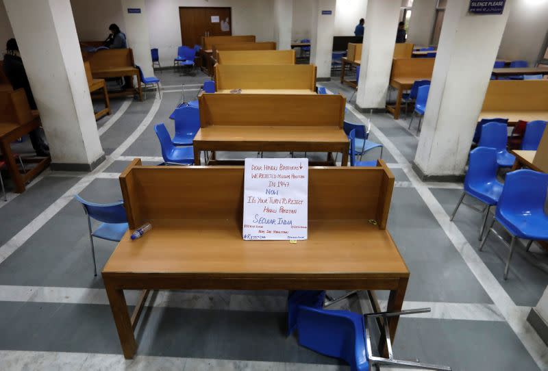 A placard lies on a table inside a partially damaged library of the Jamia Millia Islamia university in New Delhi