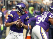 Minnesota Vikings quarterback Kirk Cousins, left, prepares to throw against the Seattle Seahawks in the first half of an NFL football game in Minneapolis, Sunday, Sept. 26, 2021. (AP Photo/Bruce Kluckhohn)