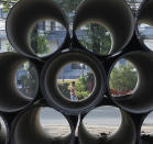 <p>A Nepalese man walks on the street seen through drinking water pipes piled at the road side in Kathmandu, Nepal, May 24, 2017. Nepal’s government is replacing all underground water pipe lines in Kathmandu which is expecting to end the acute water crisis in Kathmandu. (Photo: Narendra Shrestha/EPA) </p>