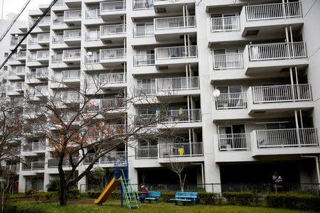 A resident sits on a bench by an apartment block, built in the 1970s, at Ojamachi district in Sakura, Chiba Prefecture, Japan, November 7, 2018. REUTERS/Kim Kyung-Hoon