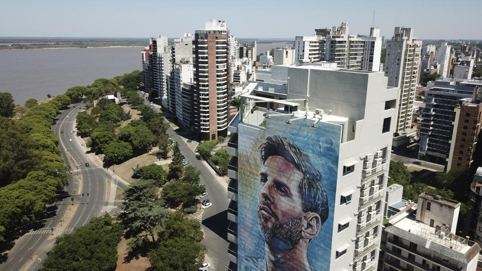 A mural of soccer player Lionel Messi covers a building near the Parana River in Rosario, Argentina, Wednesday, Dec. 14, 2022. (AP Photo/Rodrigo Abd)