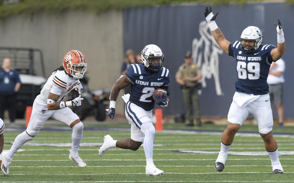 Utah State offensive lineman Falepule Alo (69) celebrates as running back Robert Briggs Jr. (2) runs for a 58-yard touchdown, while Idaho State cornerback Tylor Bohannon defends during the first half of an NCAA college football game Saturday, Sept. 9, 2023, in Logan, Utah. | Eli Lucero/The Herald Journal via AP