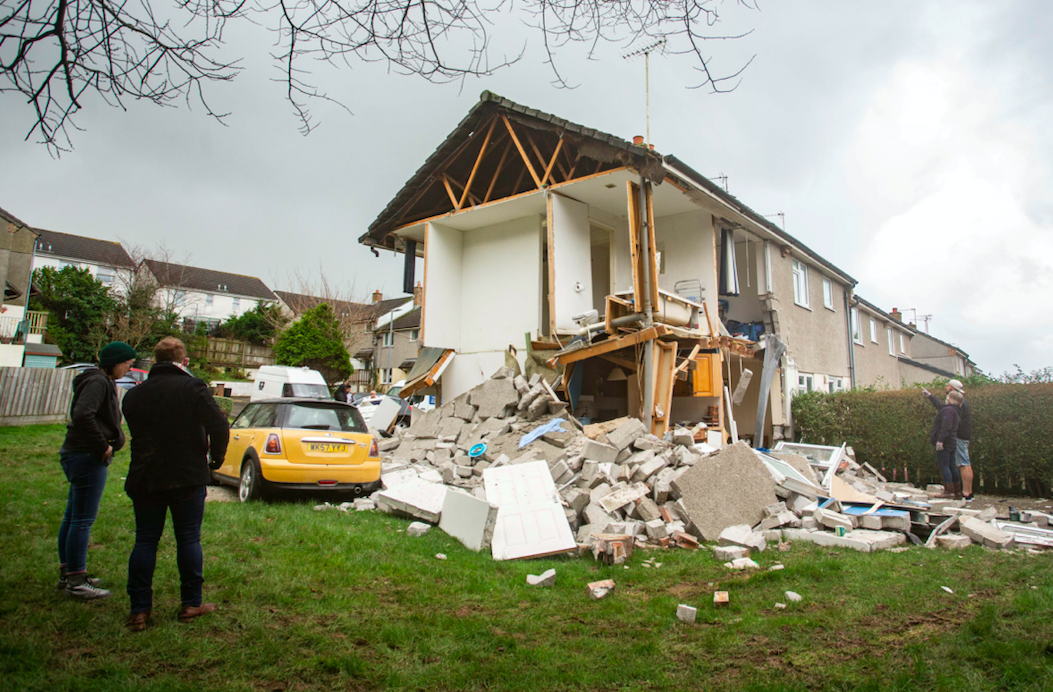 Onlookers stand outside the house following the explosion on Wednesday. (SWNS)