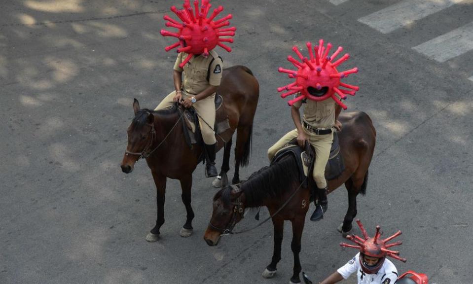 Police wearing coronavirus-awareness helmets amid a lockdown in India, where cases are rising fast.