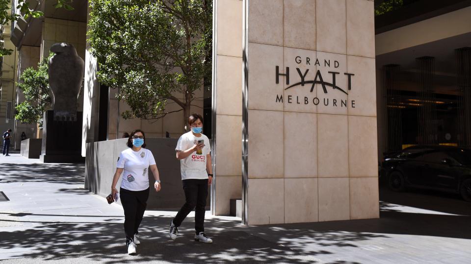 People walk past the Grand Hyatt hotel which will host tennis players and officials in Melbourne on January 14, 2021, as they quarantine ahead of the Australian Open tennis tournament.