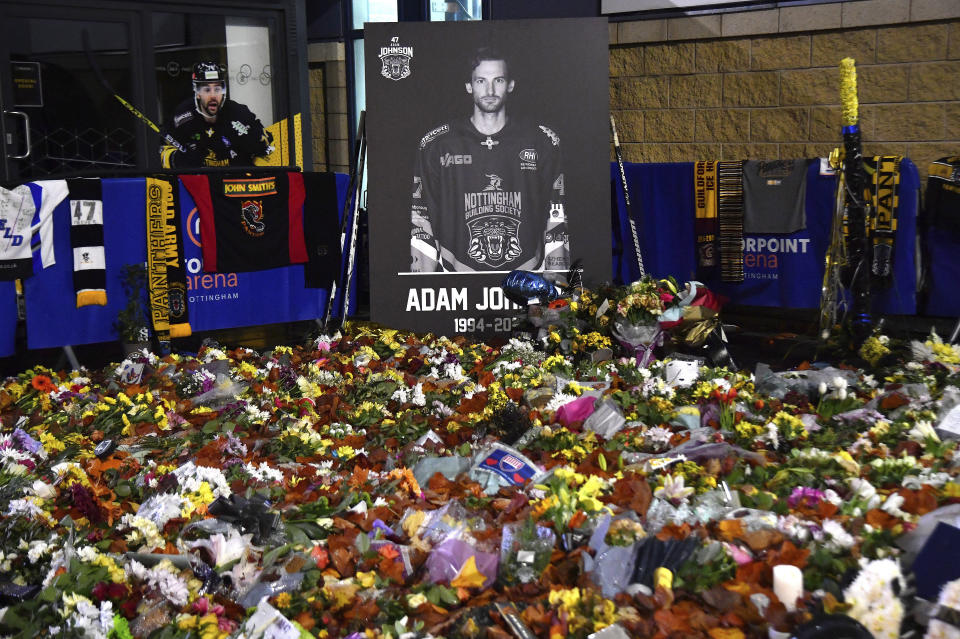 FILE - Flower tributes for Nottingham Panthers player Adam Johnson rest outside the Motorpoint Arena before a memorial ice hockey game between Nottingham Panthers and Manchester Storm in Nottingham, England, Saturday, Nov. 18, 2023. "Import” hockey players in the United Kingdom don't earn big salaries but the lifestyle and perks are pretty good. They get free use of a car and rent-free housing. These mostly Canadian and American imports are mini-celebrities around the Elite Ice Hockey League. They can also earn a master's degree tuition-free. Adam Johnson of the Nottingham Panthers was living with his fiancée and studying at a business school. (AP Photo/Rui Vieira, File)