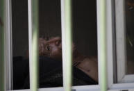 Patient Jose Da Silva talks with his son through a window as firefighters douse a blaze at the Bonsucesso Federal Hospital, as some patients are evacuated in Rio de Janeiro, Brazil, Tuesday, Oct. 27, 2020. According to the hospital, a 42-year-old female COVID-19 patient, who was in critical condition, died while she was being evacuated. (AP Photo/Silvia Izquierdo)