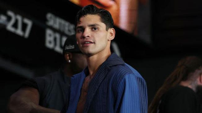 Ryan Garcia waits in a blue shirt at a weigh-in