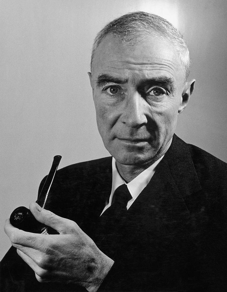 prominent american physicist and expert in atomic energy research j robert oppenheimer holding a pipe in a black suit