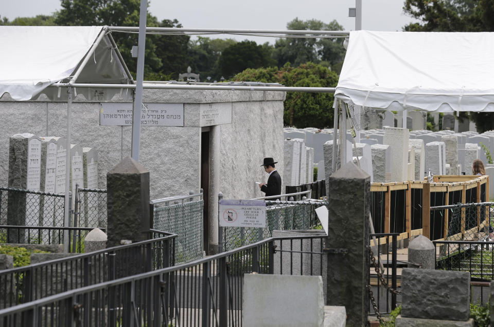 In this July 2, 2019 photo, a worshipper prays near the gravesite of Rabbi Menachem M. Schneerson in the Queens borough of New York. Rabbi Zalman Shmotkin, a spokesman for Chabad-Lubavitch, says Schneerson “served God with the holiness of simplicity, eschewing opulence and pomp, choosing instead to live a simple, almost meager existence.” (AP Photo/Seth Wenig)