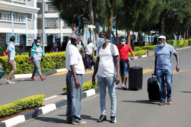 FILE PHOTO: A security person points as he orders quarantined travellers protesting being held because of the coronavirus disease outbreak for more than the usual 14 days at Kenyatta University near Nairobi