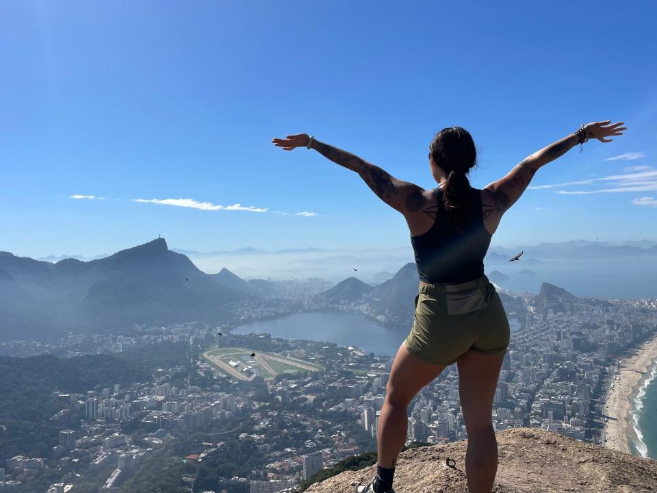 Celeste Cox on an cliffside overlooking a Brazilian city