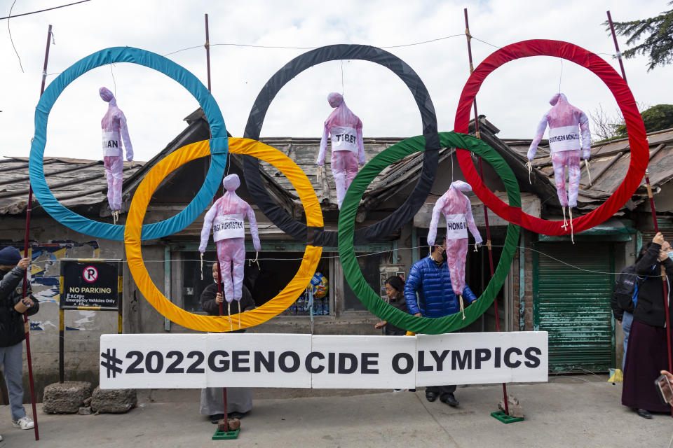 FILE - In this Feb. 3, 2021, file photo, exile Tibetans use the Olympic Rings as a prop as they hold a street protest against the holding of 2022 Winter Olympics in Beijing in Dharmsala, India. Some kind of boycott is almost sure to affect next yearâ€™s Beijing Winter Olympics.  Itâ€™s driven by the widely reported internment of several million Muslim Uyghurs and other ethnic minorities in China, which has been termed a genocide by numerous governments and human rights groups. (AP Photo/Ashwini Bhatia, File)