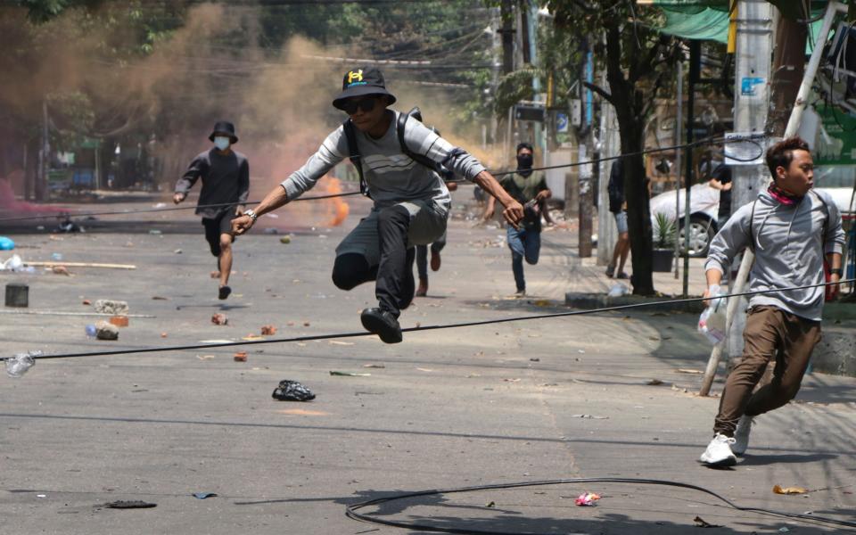 Anti-coup protesters flee the military in Yangon - AP