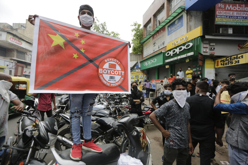 A Karni Sena supporter holds a banner calling for the boycott of Chinese products in Ahmedabad, India, Wednesday, June 24, 2020. Chinese and Indian military commanders have agreed to disengage their forces in a disputed area of the Himalayas following a clash that left at least 20 soldiers dead, both countries said Tuesday. The commanders reached the agreement Monday in their first meeting since the June 15 confrontation, the countries said. (AP Photo/Ajit Solanki)