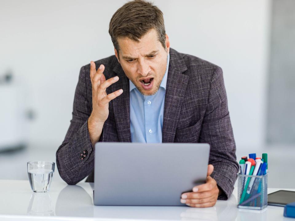 Angry man arguing during conference call on laptop