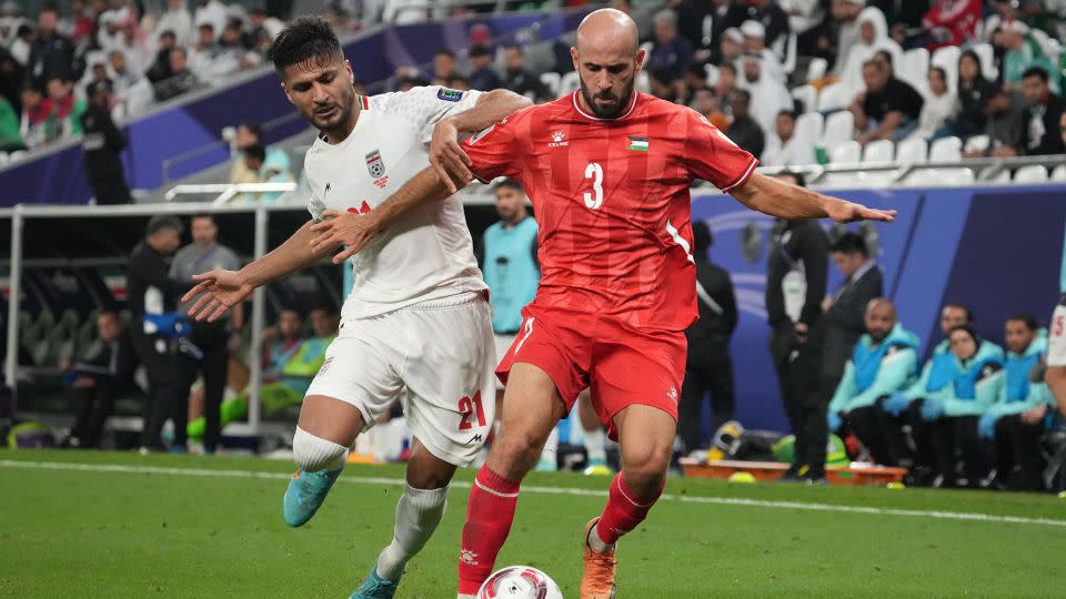 Mohammed Rashid of the Palestinian soccer team and Mohammad Mohebbi of Iran compete for the ball during the AFC Asian Cup Group C match between Iran and Palestine at Education City Stadium on January 14, 2024 in Al Rayyan, Qatar. - Masashi Hara/Getty Images