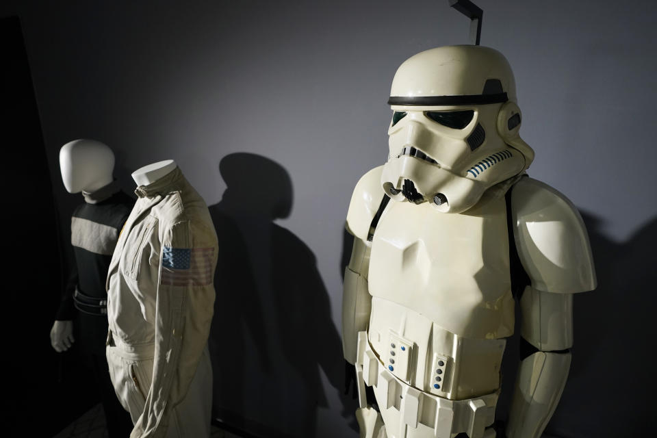 FILE - An imperial Stormtrooper costume, right, from the 1977 film "Star Wars, Episode IV, A New Hope," sits on display by other items of the Greg Jein collection at Heritage Auctions, Aug. 30, 2023, in Irving, Texas. A miniature X-wing Starfighter used in a “Star Wars” film sold for over $3 million on Sunday, Oct. 15, during a weekend auction of items both collected and created by longtime Hollywood model maker Greg Jein. The collection amassed by Jein, who died last year at the age of 76, brought in about $13.6 million during a weekend event at Heritage Auctions in Dallas. (AP Photo/Tony Gutierrez, File)