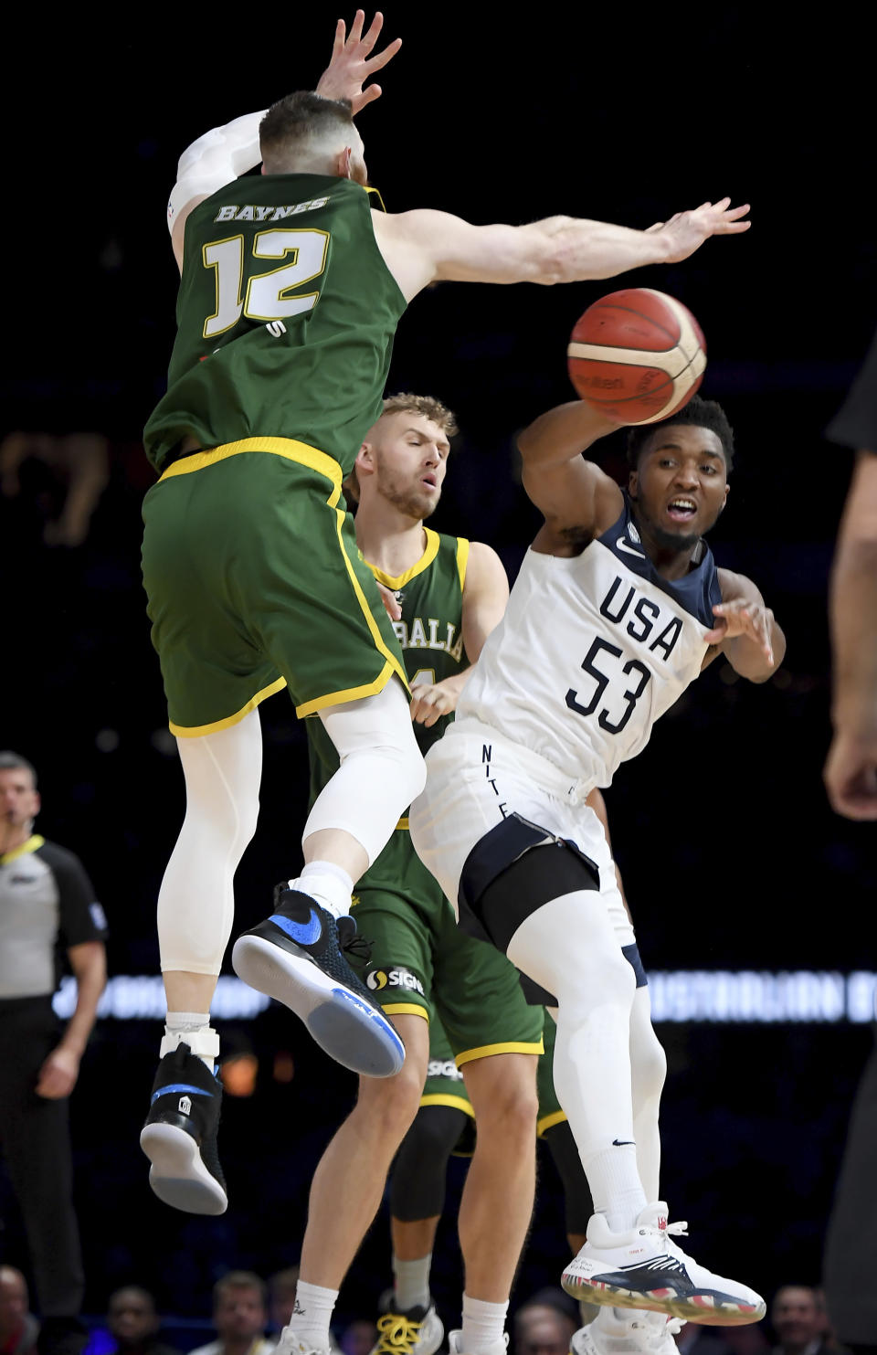 United States' Donovan Mitchell passes the ball against Australia's Aron Baynes during their exhibition basketball game in Melbourne, Thursday, Aug. 22, 2019. (AP Photo/Andy Brownbill)