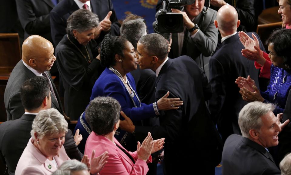 U.S. President Obama kisses U.S. Rep Sheila Jackson Lee as he arrives to deliver his State of the Union address to a joint session of Congress in the U.S. Capitol in Washington