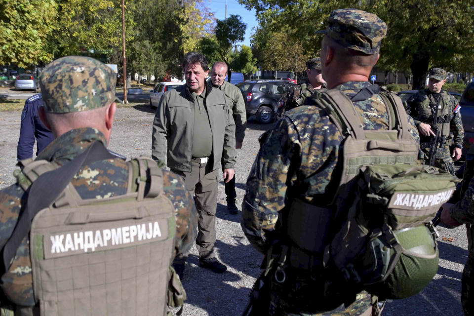 In this photo provided by the Serbian Interior Ministry, Serbian Interior Minister Bratislav Gasic speaks with police officers near the border between Serbia and Hungary, Serbia, Saturday, Oct. 28, 2023. Serbian police have arrested six people and seized automatic weapons after a shooting between migrants near the country's tense border with Hungary killed three people and injured one. (Serbian Ministry of Interior via AP)