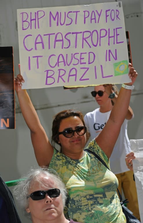 A protester displays a sign outside the BHP Billiton annual general meeting in Perth, on November 19, 2015