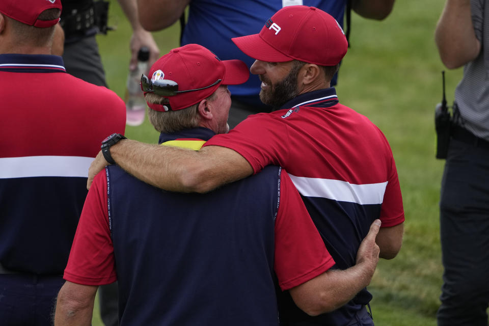 Team USA captain Steve Stricker hugs Team USA's Dustin Johnson after a Ryder Cup singles match at the Whistling Straits Golf Course Sunday, Sept. 26, 2021, in Sheboygan, Wis. (AP Photo/Jeff Roberson)