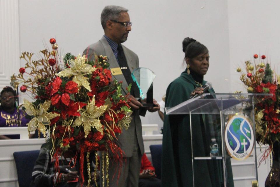 The Rev. Milford Griner, left, founder and president of the Rosa Parks Quiet Courage Committee, holds a plaque as RPQCC 2nd Vice President Karen Cole-Smith, Ph.D., reads a biography of one of the honorees during the committee's annual awards ceremony.