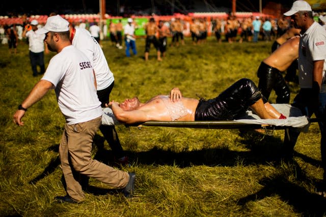 An injured wrestler is taken out on a stretcher