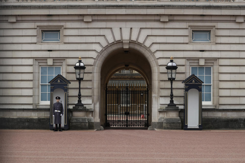 A member of the military stands guard outside Buckingham Palace, the official London residence of Britain's Queen Elizabeth II in central London, Sunday, March 7, 2021. The time has finally come for audiences to hear Meghan and Harry describe the backstory and effects of their tumultuous split from royal life, during an interview with U.S. TV host Oprah Winfrey, and British audiences will wake up Monday to headlines and social media posts. (AP Photo/Matt Dunham)