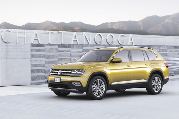 A yellow VW Atlas, a midsize seven-passenger SUV, shown parked in front of a city sign in Chattanooga, Tennessee